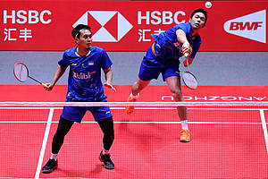 Hendra Setiawan/Mohammad Ahsan mengembalikan shuttlecock.
