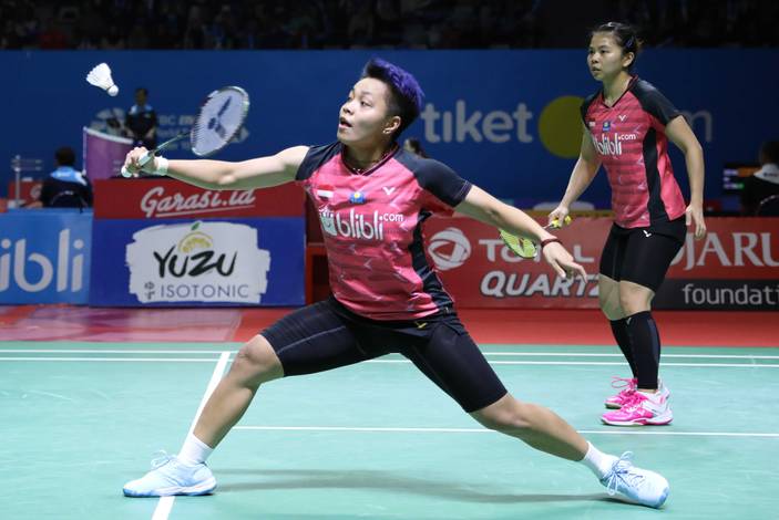 Greysia Polii/Apriyani Rahyu (Indonesia) mengembalikan shuttlecock.
