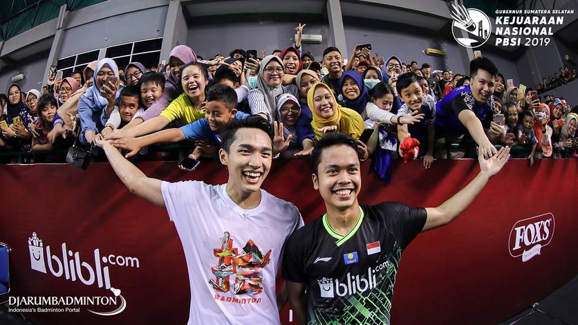 Jonatan Christie (kiri) dan Anthony Sinisuka Ginting berfoto bersama para penggemar selepas laga eksebisi di GOR Dempo Jakabaring Sport City, Palembang, Minggu (24/11).