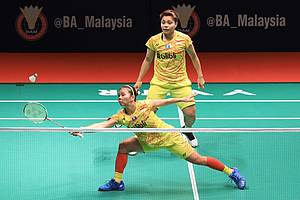 Greysia Polii/Apriyani Rahayu mengembalikan shuttlecock.