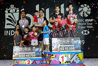 Kevin Sanjaya Sukamuljo/Marcus Fernaldi Gideon (kanan) dan Hendra Setiawan/Mohammad Ahsan di atas podium juara bersama para buah hatinya.