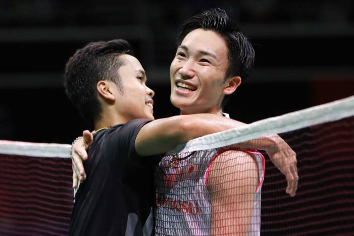 Anthony Sinisuka Ginting (kiri) berpelukan dengan Kento Momota (Jepang) usai bertanding.