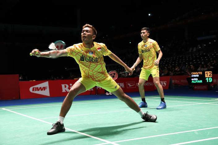 Fajar Alfian/Muhammad Rian Ardianto mengembalikan shuttlecock.