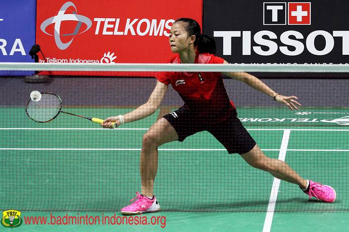 Fitriani mengembalikan shuttlecock.