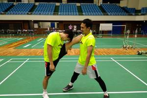 Mohammad Ahsan (kanan) saat membantu Marcus Fernaldi Gideon peregangan. (Foto: PP PBSI)