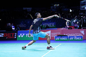 Tommy Sugiarto (Indonesia) mengembalikan shuttlecock.