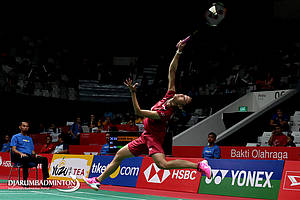 Fitriani mengembalikan shuttlecock.