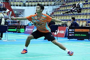Christian Adinata (Indonesia) mengembalikan shuttlecock.