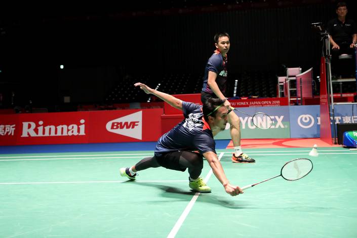 Hendra Setiawan/Mohammad Ahsan mengembalikan shuttlecock.