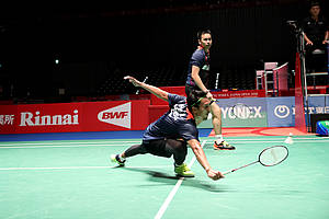 Hendra Setiawan/Mohammad Ahsan mengembalikan shuttlecock.
